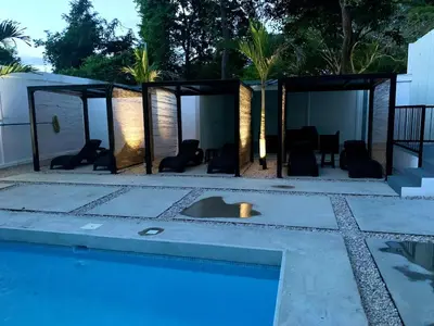 a swimming pool with chairs and a house at Whitestone Parkview Tamarindo in Tamarindo