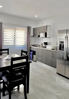 a kitchen with a table and a refrigerator at Whitestone Parkview Tamarindo in Tamarindo