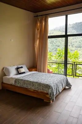 a bedroom with a bed and a large window at Vista Canaan Cabaña de montaña in Rivas