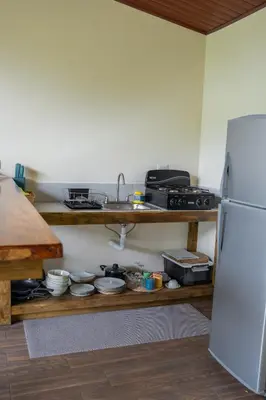 a kitchen with a sink and a refrigerator at Vista Canaan Cabaña de montaña in Rivas