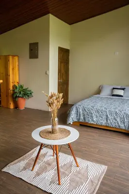 a bedroom with a bed and a table with a bed at Vista Canaan Cabaña de montaña in Rivas