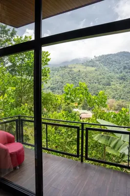 a room with a balcony with a view of the forest at Vista Canaan Cabaña de montaña in Rivas