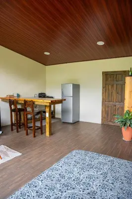 a dining room with a table and a refrigerator at Vista Canaan Cabaña de montaña in Rivas