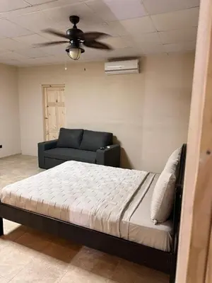 a bedroom with a bed and a couch at Apartamentos MarSol in Uvita