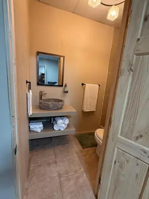 a bathroom with a sink and a mirror and a toilet at Apartamentos MarSol in Uvita