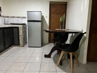 a kitchen with a table and a refrigerator at Casa de Campo Nara in Fortuna