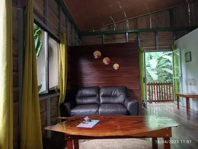a living room with a leather couch and a table at Cabaña nido de amor escondida en la naturaleza in San Francisco