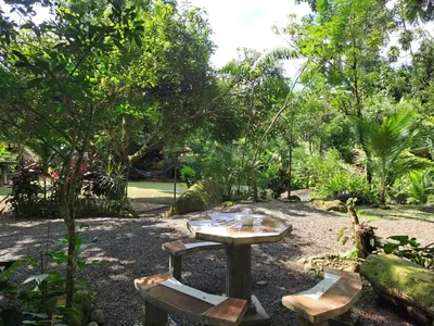 a picnic table and two chairs in a garden at Cabaña nido de amor escondida en la naturaleza in San Francisco