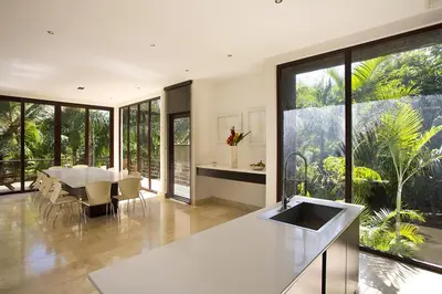 a kitchen and dining room with a table and a large window at Villa Cala Honda, Private Beachfront Escape in Santa Cruz