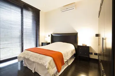 a bedroom with a bed with an orange blanket on it at Villa Cala Honda, Private Beachfront Escape in Santa Cruz