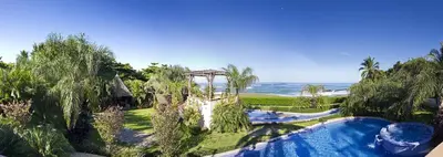 a resort with a swimming pool next to the ocean at Villa Cala Honda, Private Beachfront Escape in Santa Cruz