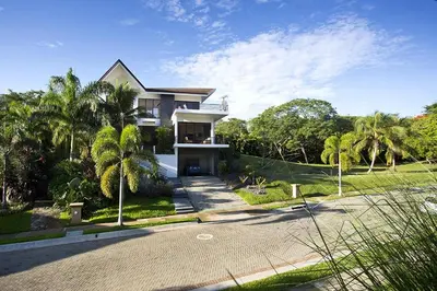 a large house on a street with palm trees at Villa Cala Honda, Private Beachfront Escape in Santa Cruz