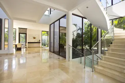 a living room with a staircase in a house at Villa Cala Honda, Private Beachfront Escape in Santa Cruz