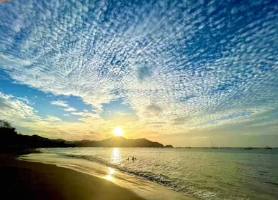 a sunset on the beach with a cloudy sky at Casa Aurora with Private Patio & Pool in Coco