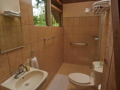 a bathroom with a sink and a toilet at Santa Maria Volcano Lodge Hotel & Restaurante in Hacienda Santa María