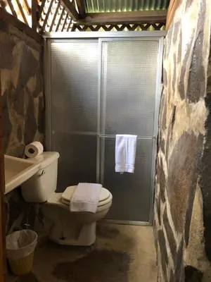 a bathroom with a shower with a toilet and a sink at Santa Maria Volcano Lodge Hotel & Restaurante in Hacienda Santa María