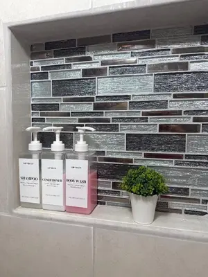 a shelf with three bottles of soap and a plant at Beautiful loft in San José in San José