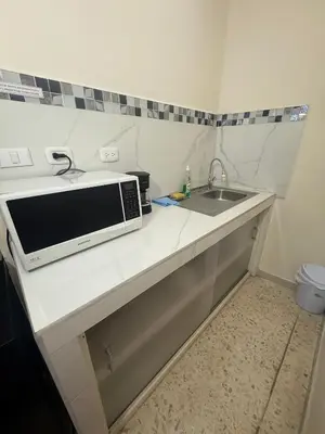 a kitchen counter with a microwave and a sink at Beautiful loft in San José in San José