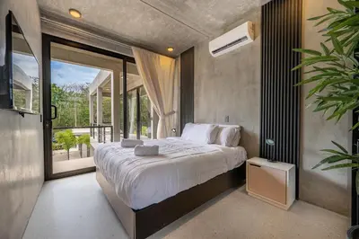 a bedroom with a large bed and a large window at Nelblu Flamingo Suites in Playa Flamingo