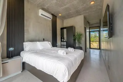 a bedroom with a large bed with towels on it at Nelblu Flamingo Suites in Playa Flamingo