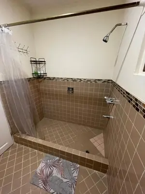 a shower in a bathroom with a tiled floor at Mini-apartment located in the heart of San José in San José