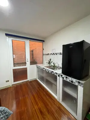 a living room with a large television and a kitchen at Mini-apartment located in the heart of San José in San José
