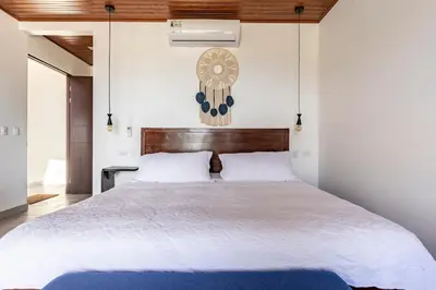 a bedroom with a large bed with a clock on the wall at Casa Coroico Infinity Pool BBQ Sunset Views in Santa Cruz