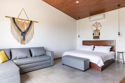 a bedroom with a bed and a couch at Casa Coroico Infinity Pool BBQ Sunset Views in Santa Cruz