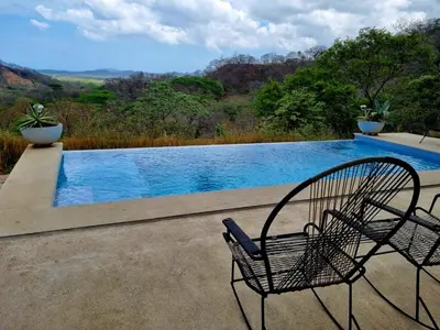 a chair sitting in front of a swimming pool at Casa Coroico Infinity Pool BBQ Sunset Views in Santa Cruz