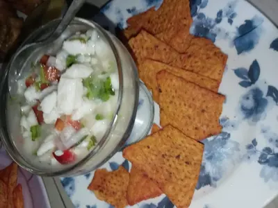 a plate with a bowl of dip and chips at Casa de árbol familiosa in Tapantí