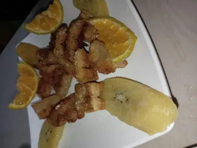 a plate of food with bacon and orange slices at Casa de árbol familiosa in Tapantí