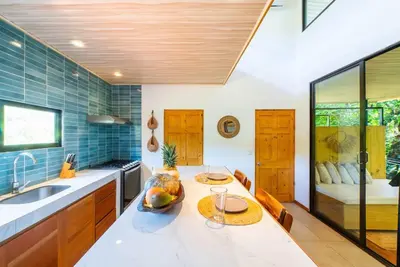 a kitchen with a table and a sink and a counter at New, Private River, Wifi, AC, King Bed, Jungle Shower in Ojochal