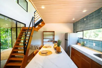 a kitchen with a spiral staircase in a house at New, Private River, Wifi, AC, King Bed, Jungle Shower in Ojochal