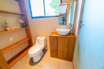 a bathroom with a toilet and a sink at New, Private River, Wifi, AC, King Bed, Jungle Shower in Ojochal