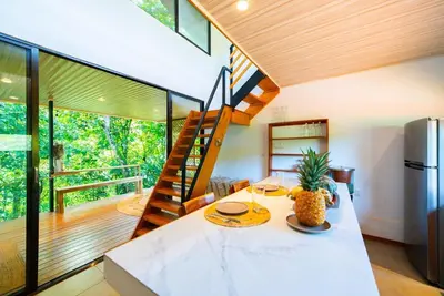 a living room with a staircase in a house at New, Private River, Wifi, AC, King Bed, Jungle Shower in Ojochal