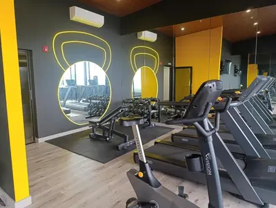 a gym with treadmills and ellipticals in a room at Lovely comfy studio in the city, with AC in San José