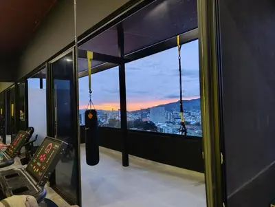a gym with a view of the city from the window at Lovely comfy studio in the city, with AC in San José
