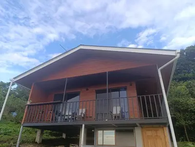 a house with a balcony with chairs on it at Finca Alta Vista Monteverde in Monteverde Costa Rica