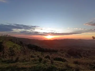 a sunset in the mountains with the sun setting at Finca Alta Vista Monteverde in Monteverde Costa Rica