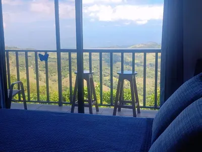 a room with two stools and a balcony with a view at Finca Alta Vista Monteverde in Monteverde Costa Rica