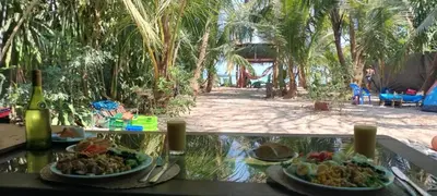 a table with two plates of food and a bottle of wine at Paradise in Puntarenas