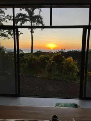 a view of a sunset through a window at Driftwood ocean view in Playa Ostional