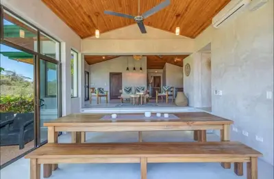 a dining room with a table and a ceiling fan at Driftwood ocean view in Playa Ostional
