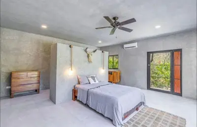 a bedroom with a bed and a ceiling fan at Driftwood ocean view in Playa Ostional