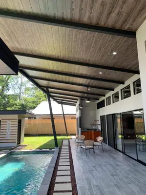 a patio with a swimming pool and a wooden ceiling at Eben-ezer #1 in Uvita