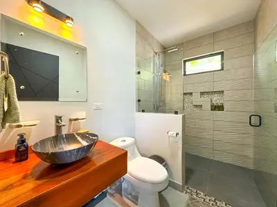 a bathroom with a sink and a toilet and a shower at Eben-ezer #1 in Uvita