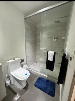 a bathroom with a toilet and a glass shower at Apartamento Vista 11 URBN Escalante in San José