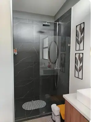 a bathroom with a shower with a mirror and a sink at Casa Grande Pura Vida in Fortuna