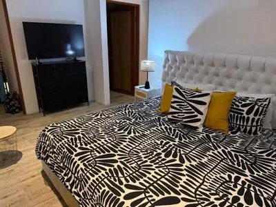 a bedroom with a black and white bed with yellow pillows at Casa Grande Pura Vida in Fortuna