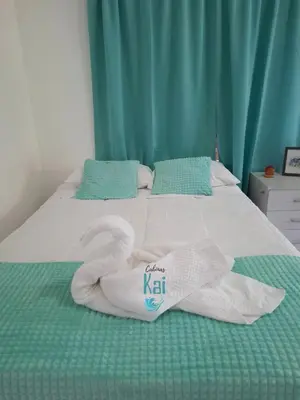 a bed with a swan made out of towels at Cabinas Kai in Quepos